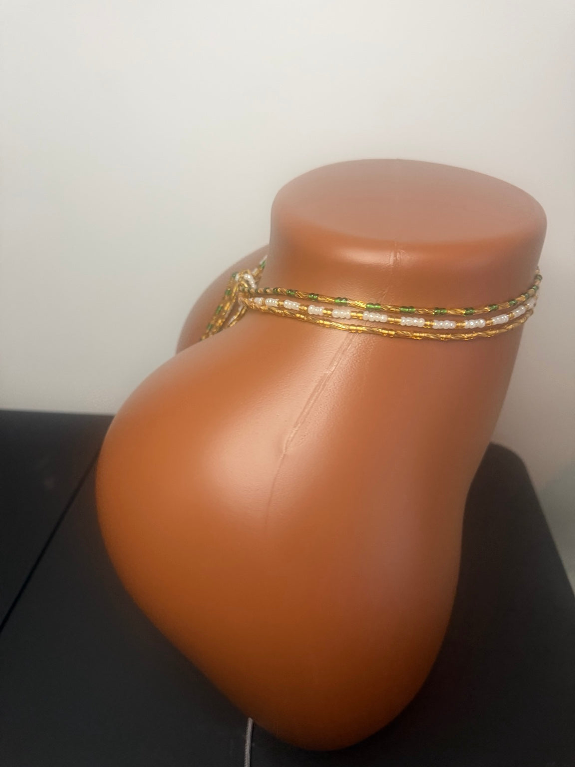 Emerald Luxe: 3 separate tie-on waist bead strands; Emerald Green & Gold, Pearl & Gold, Classic Gold. Actual product photo on display mannequin.