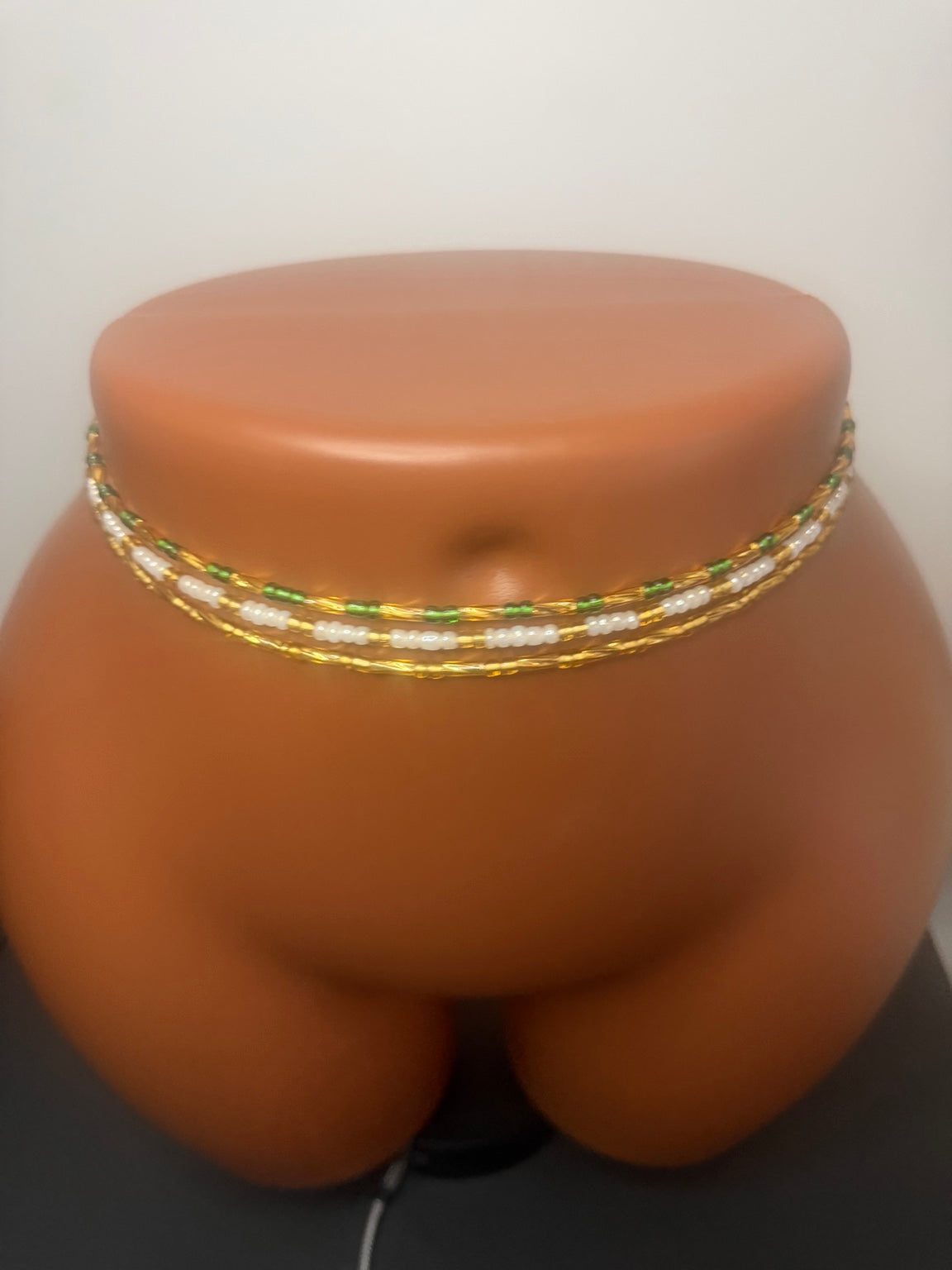 Emerald Luxe: 3 separate tie-on waist bead strands; Emerald Green & Gold, Pearl & Gold, Classic Gold. Actual product photo on display mannequin.