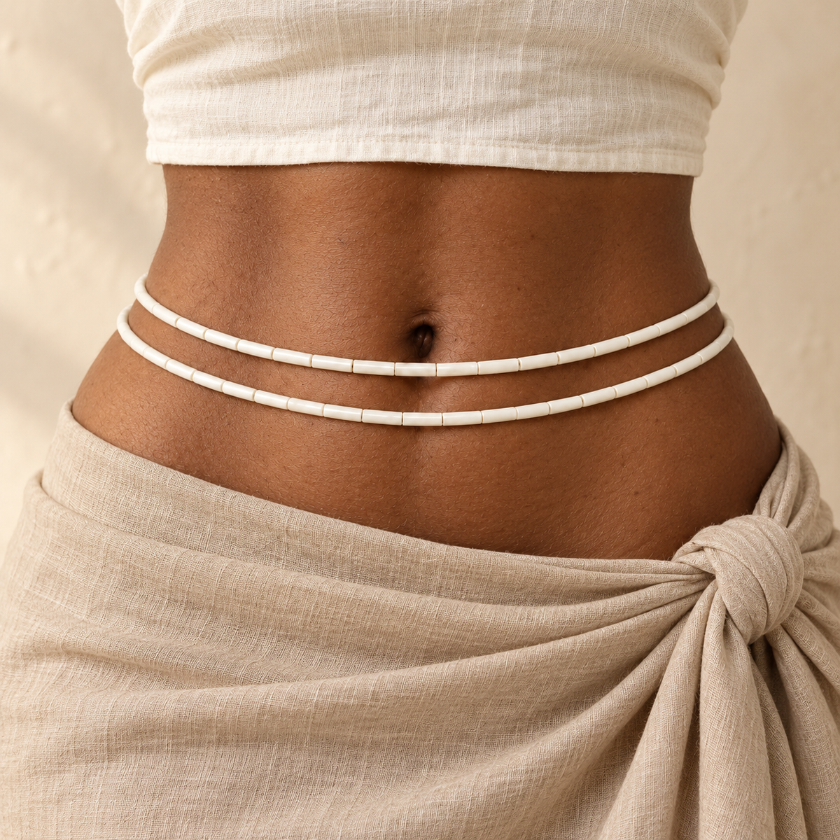 White Czech Glass waist beads on adult model with natural linen styling. Two strands shown; one strand per purchase.